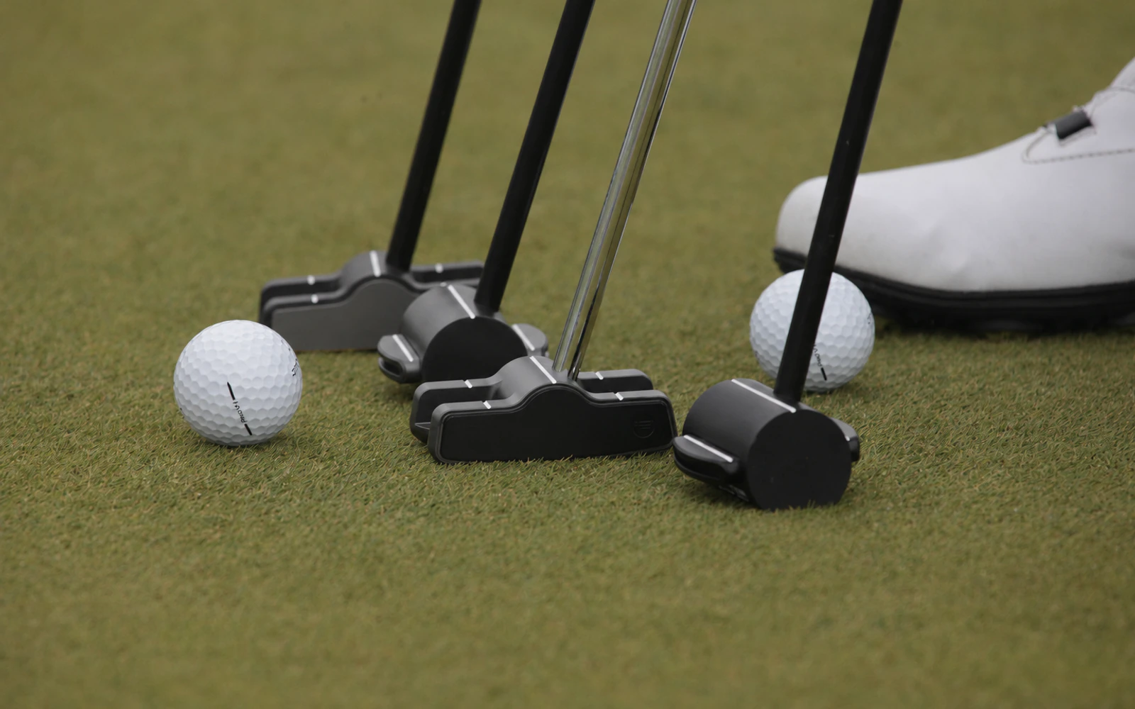 Four iBPUTTER Sweet Spot models arranged on a putting green