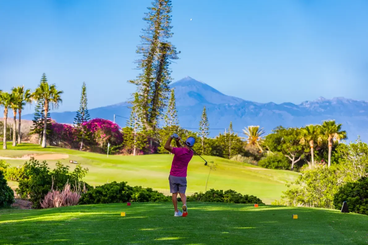 Golfer playing Tecina Golf with Mount Teide in the distance